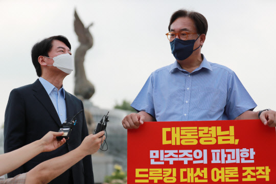 29일 안철수 국민의당 대표가 서울 종로구 청와대 분수대 앞에서 '드루킹 댓글 사건' 관련 1인 시위를 벌이고 있는 정진석 국민의힘 의원 만나 대화하고 있다. 연합뉴스.